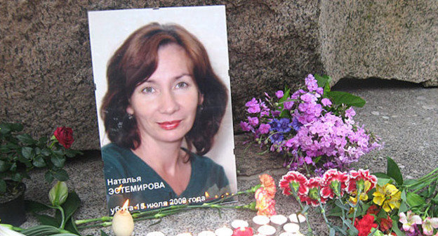 Портрет Натальи Эстемировой у Соловецкого камня на Троицкой площади, установленный во время траурного пикета. Санкт-Петербург, 15  июля 2009 г. Фото Ирины Флиге, НИЦ "Мемориал" http://www.hro.org/